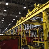 Large industrial facility with yellow overhead equipment where combustible dust cleaning is being performed to reduce fire hazards.